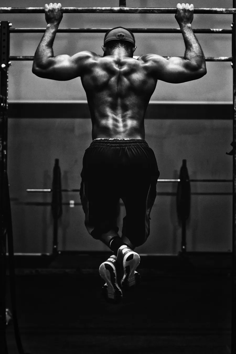 A strength athlete mid-pull-up in stark black and white