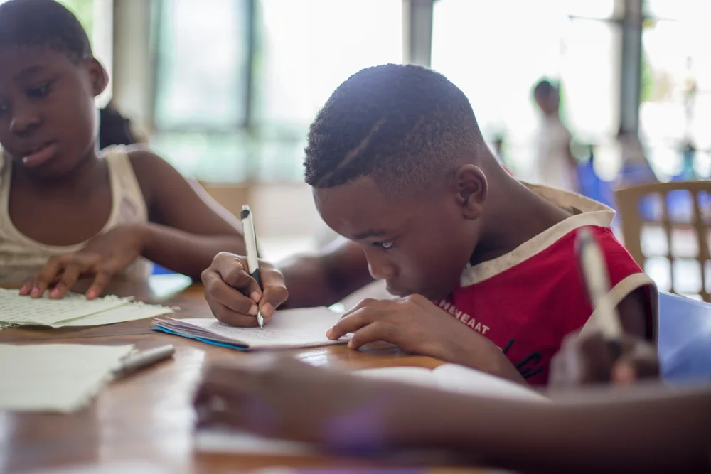 A child focused on schoolwork at an after-school table